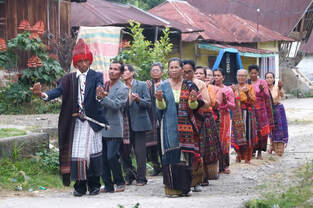 A group of Sumatran people in traditional ropes welcoming travelers