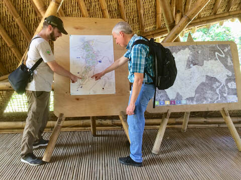 2 travelers checking out a standup map at Orangutan Haven in Sumatrahaven