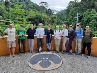 A group of travelers at a tree plantation in front of the rainforest in Sumatra