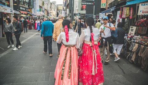 Two women in traditional costumes on a busy street in Jeonju South Korea